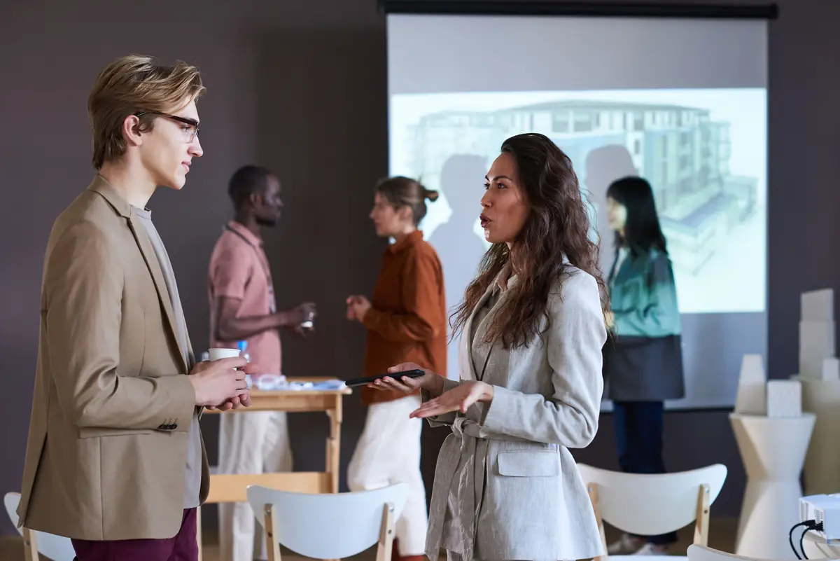 Real estate professionals discussing a development in front of a building render